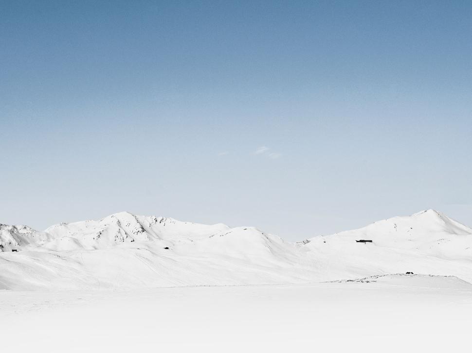 Free Image of Snow-covered mountains against a clear blue sky 