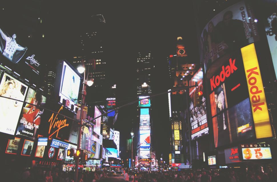 Free Image of Bustling city street at night with colorful neon lights 
