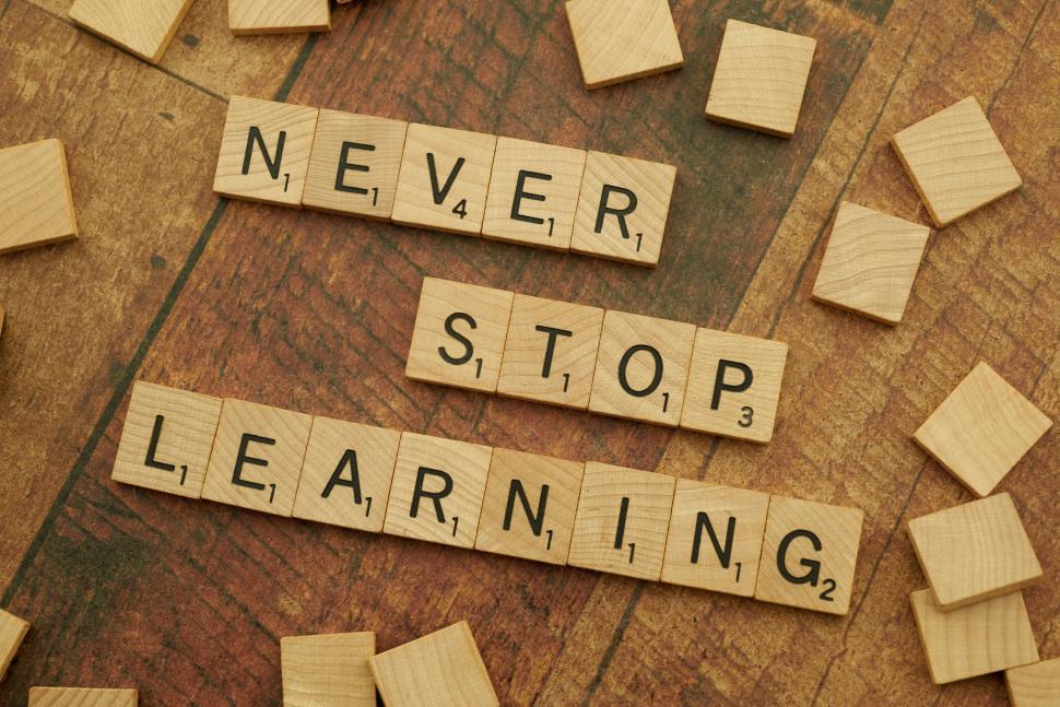Free Image of Tiles forming phrase Never Stop Learning on wooden table 
