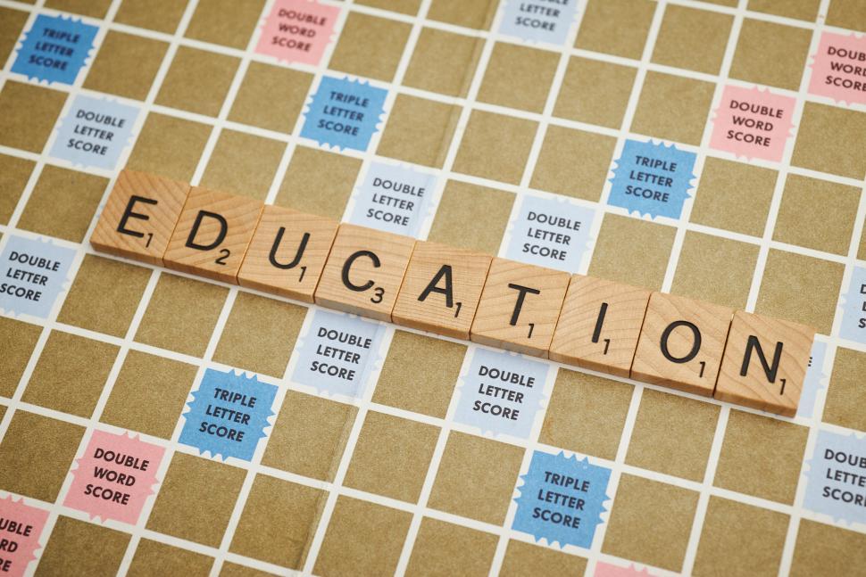 Free Image of The word Education formed with Scrabble tiles on board 