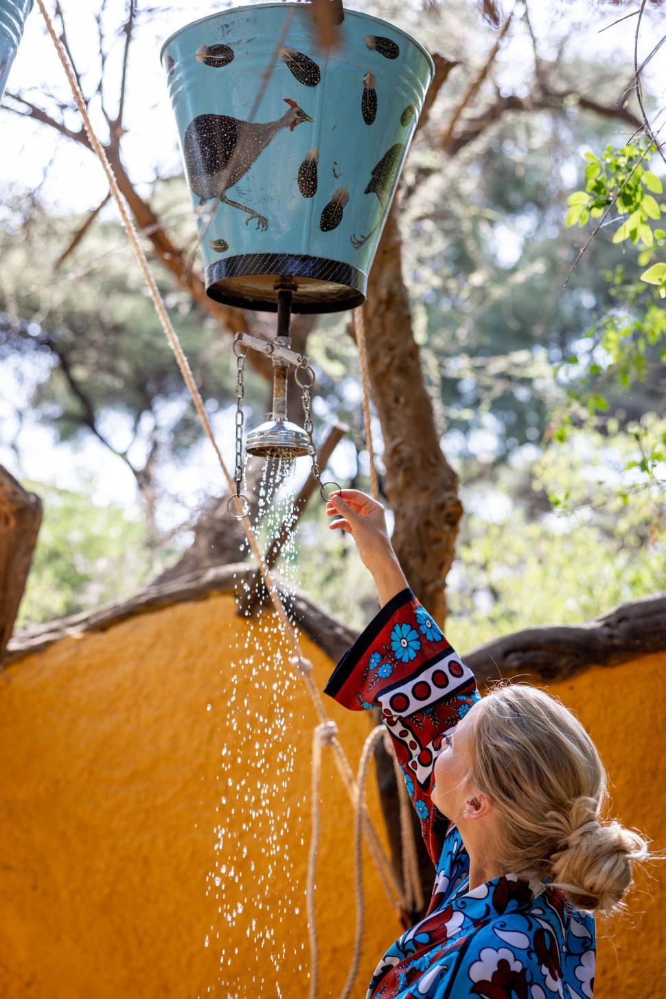 Free Image of Person reaching up to a decorative water dispenser 