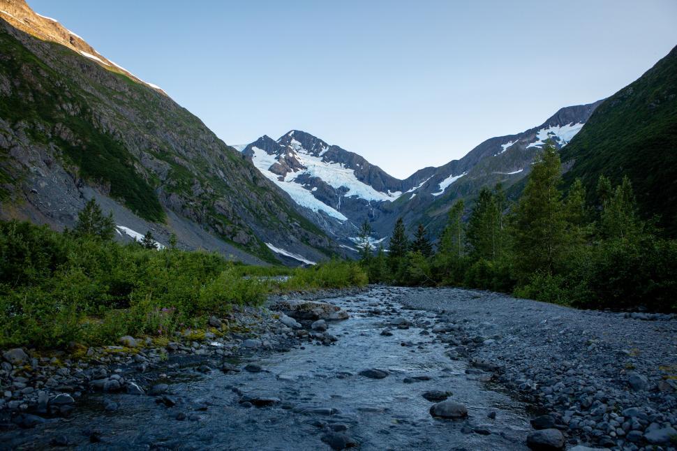 Free Image of Majestic mountain view with a clear stream in foreground. 