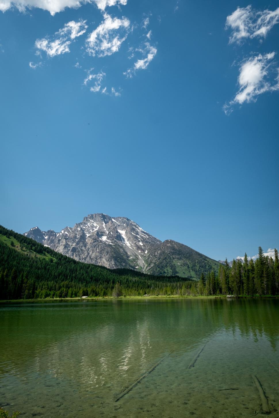 Free Image of Mountain landscape with clear lake and blue sky above. 