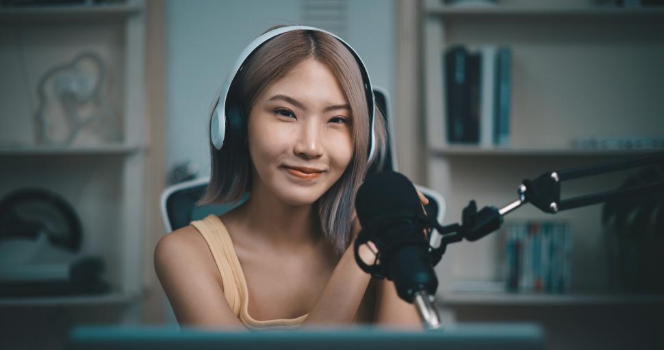 Free Image of Cheerful Young podcaster use microphone during online podcast in studio 