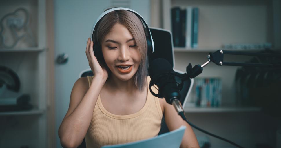 Free Image of Cheerful Young podcaster use microphone during online podcast in studio 