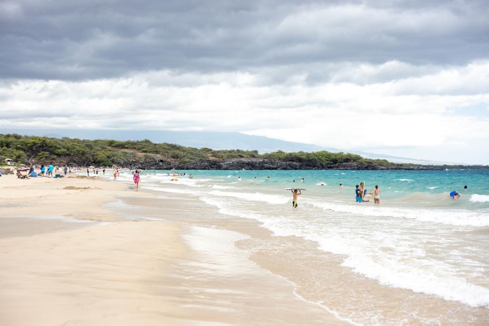 Free Image of Beach scene with people enjoying turquoise ocean waves 
