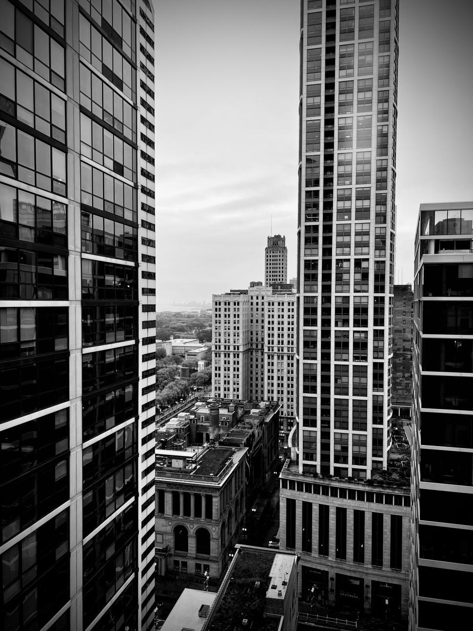 Free Image of Tall buildings surround a bustling downtown street in Chicago on a cloudy day 