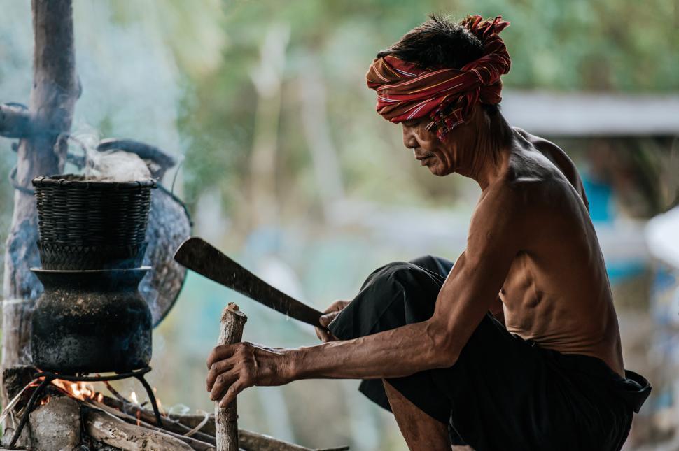 Free Image of Senior man use knife cut wood make firewood for cooking 