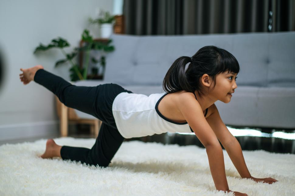 Free Image of girl doing yoga in room on white carpet 