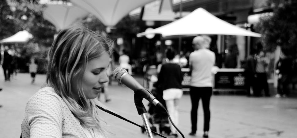 Free Image of Street performer singing and playing music outdoors. 