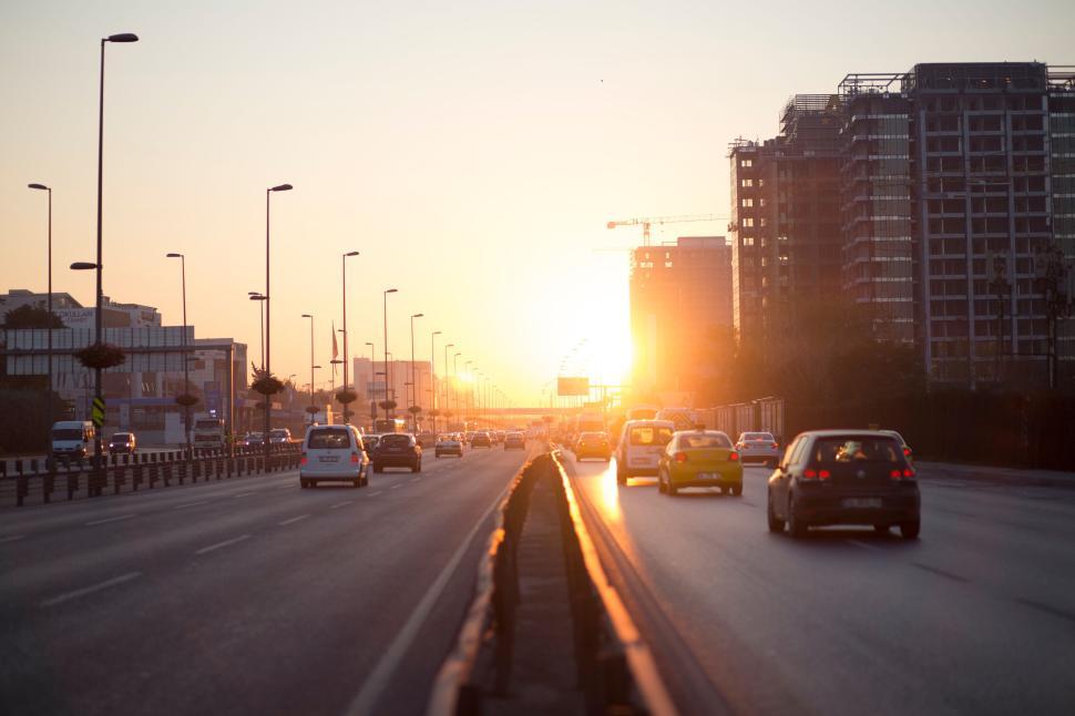 Free Image of Busy city highway with cars, buildings, and evening light 