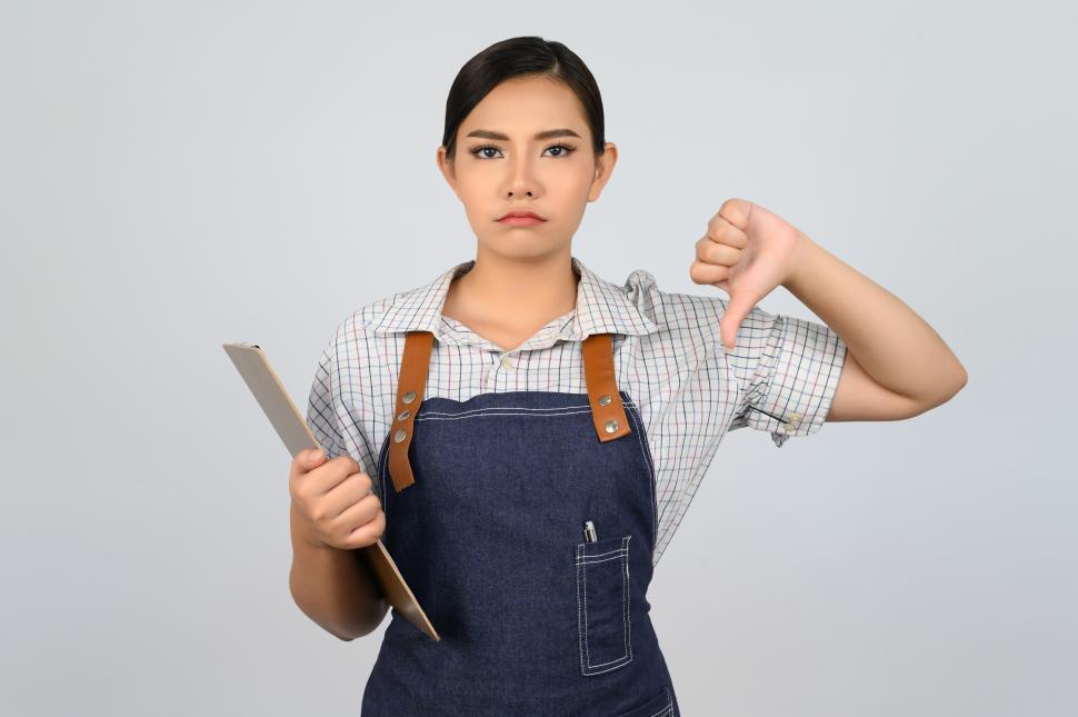 Free Image of Portrait of young asian woman in waitress uniform pose with clipboard 