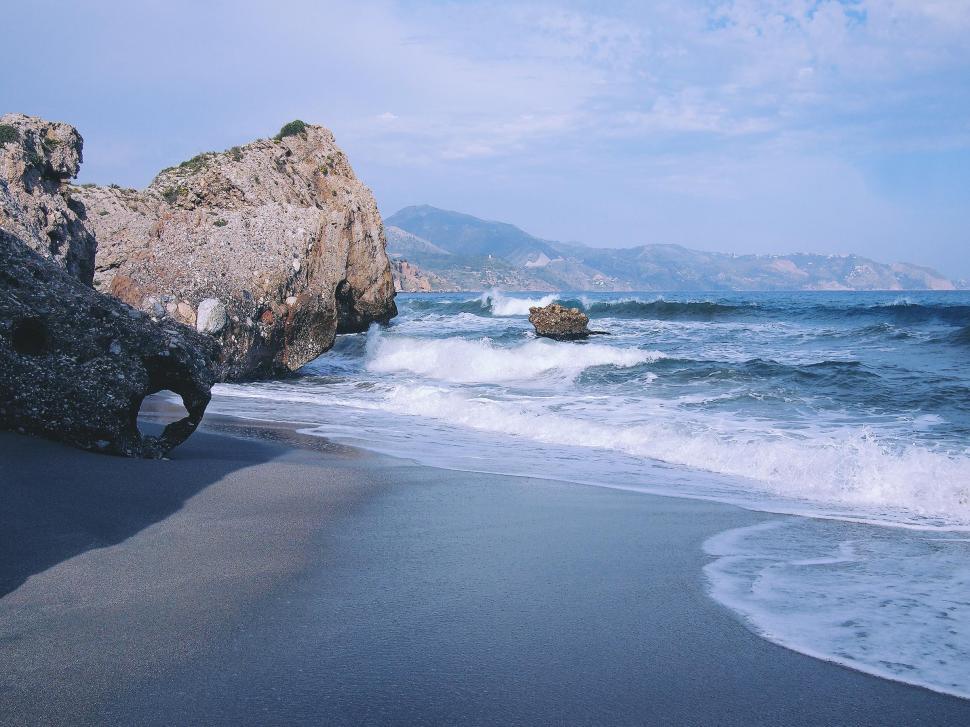 Free Image of Waves crashing on rocky beach at coastal location 