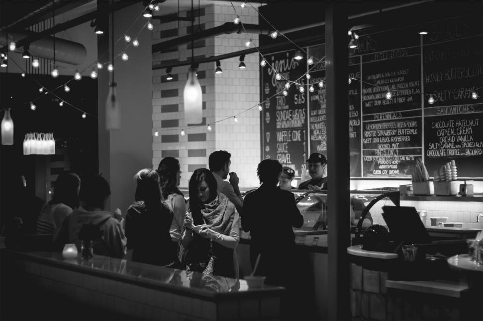 Free Image of Busy cafe evening with customers ordering desserts 