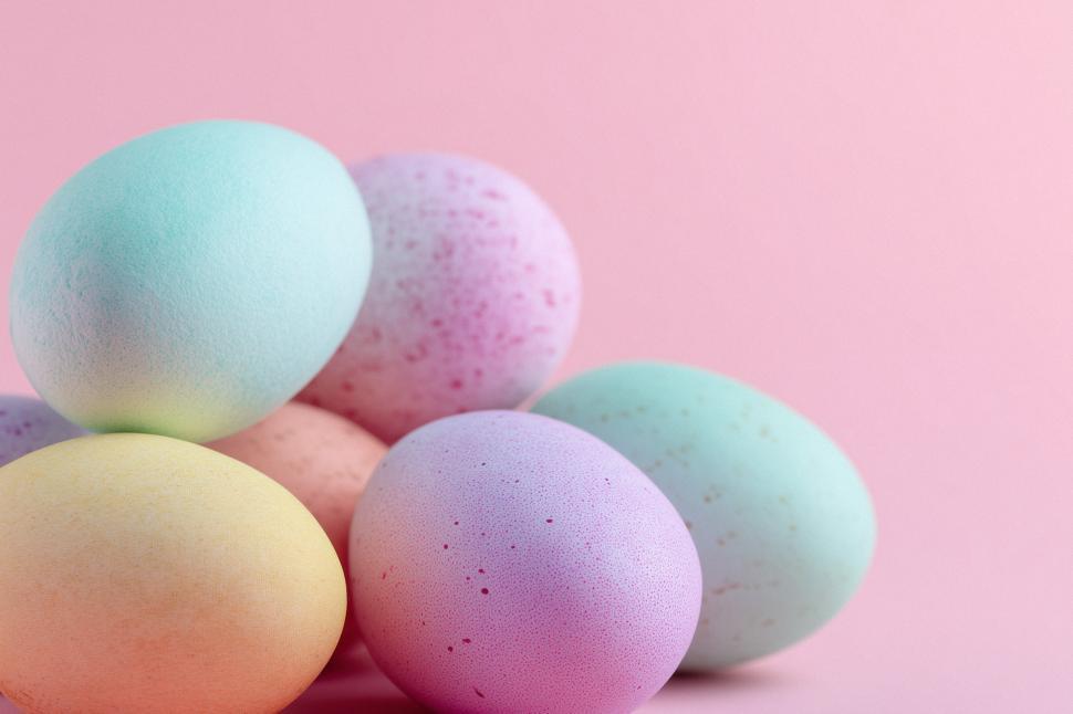 Free Image of Colorful pastel eggs arranged on a pink background 