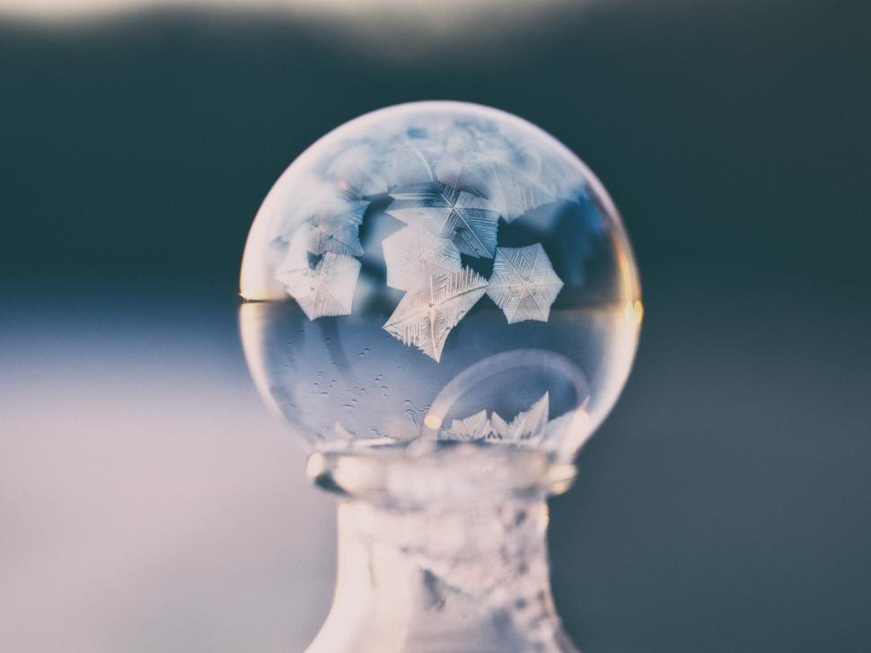 Free Image of Delicate frost crystals captured inside a glass globe on a cool morning 