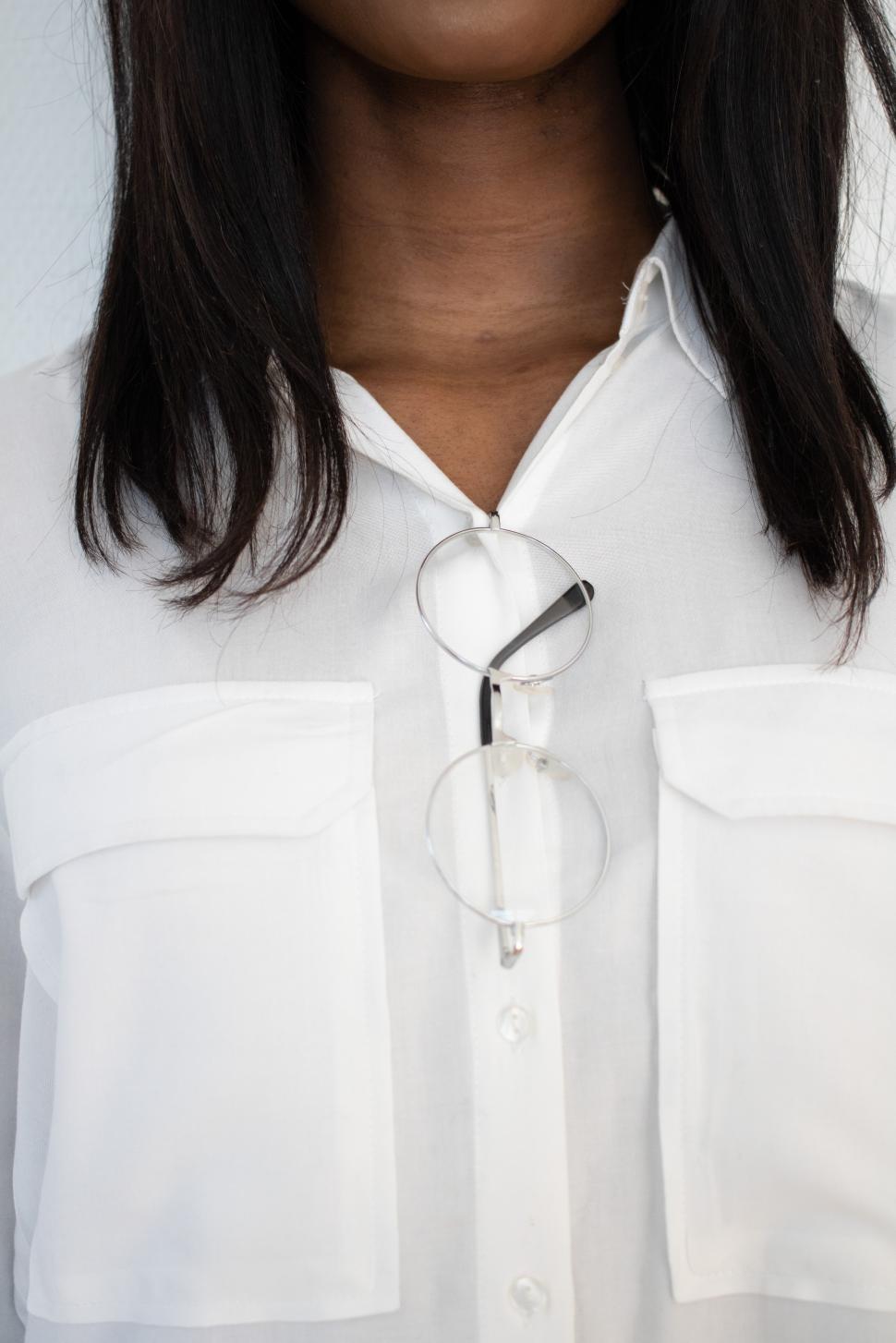 Free Image of Close-up of a woman wearing a white blouse and glasses 