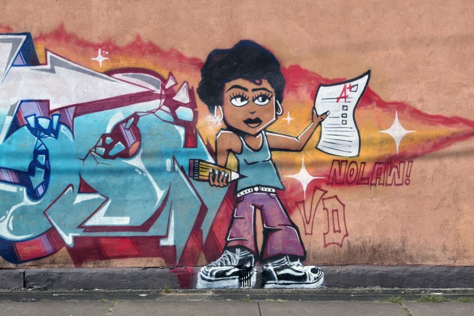 Free Image of Colorful mural featuring a confident girl holding a report card in an urban setting 