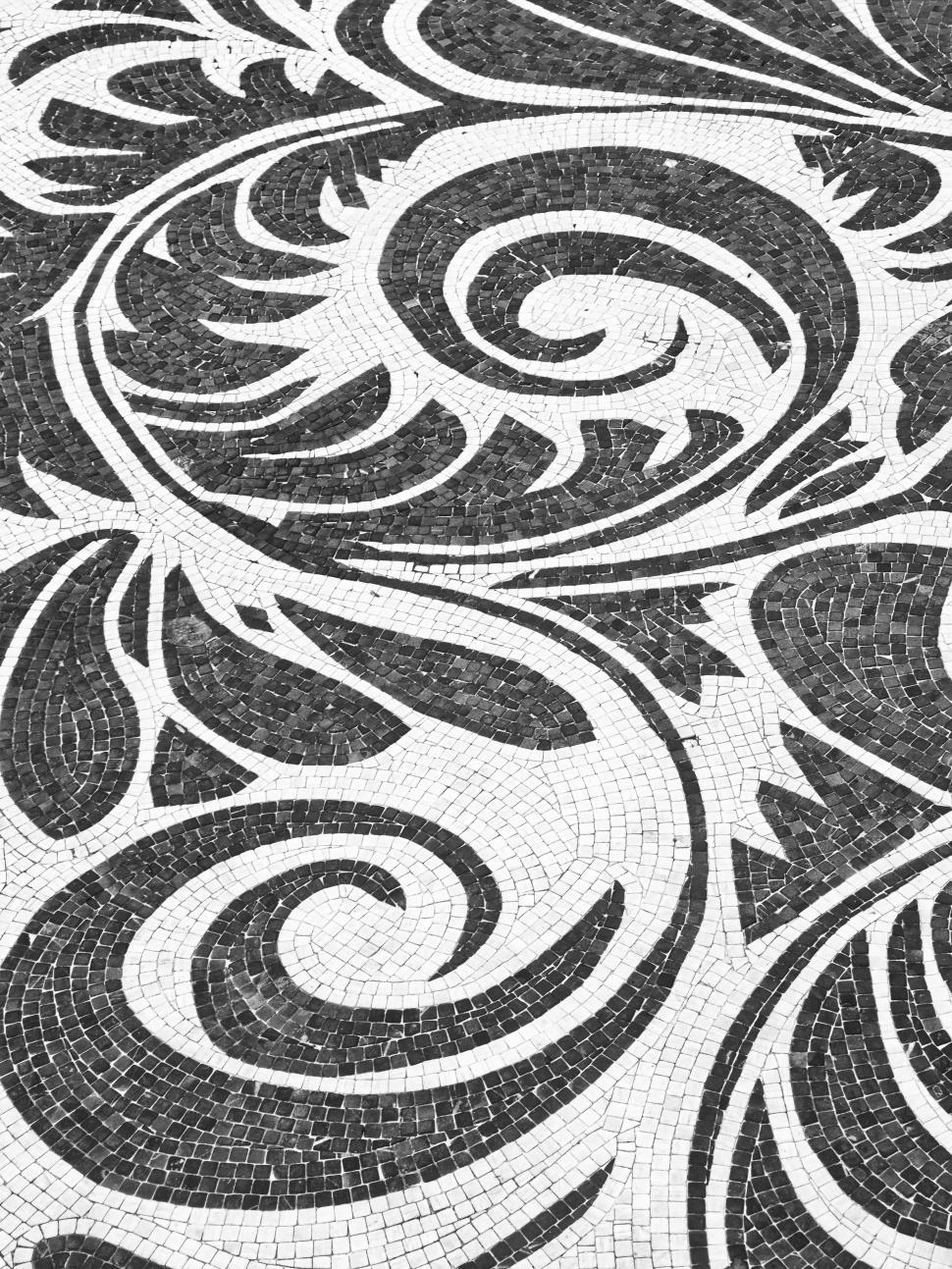Free Image of Intricate black and white mosaic design on a pavement in a city square 
