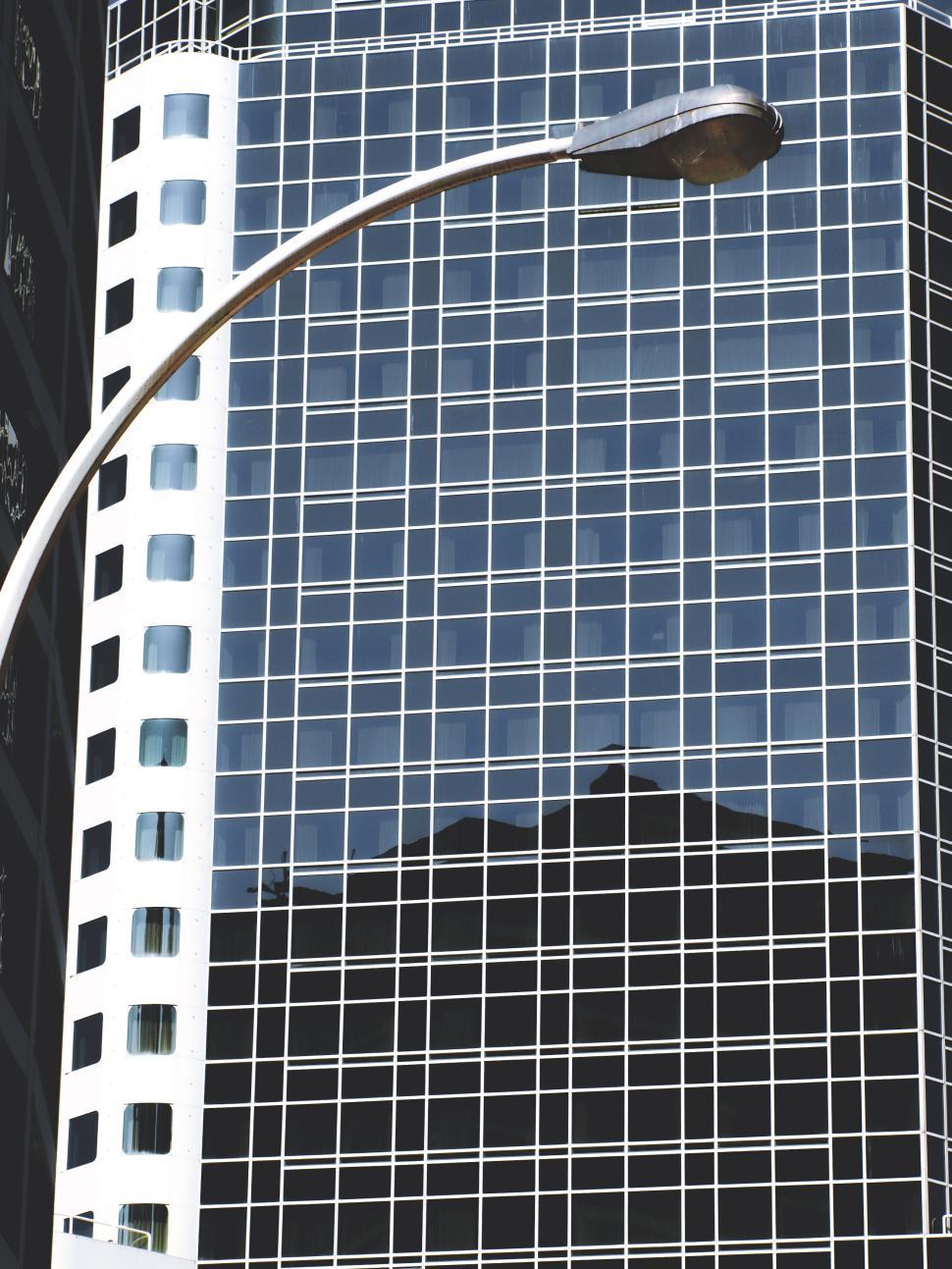 Free Image of Modern skyscraper reflections with streetlight in an urban setting 