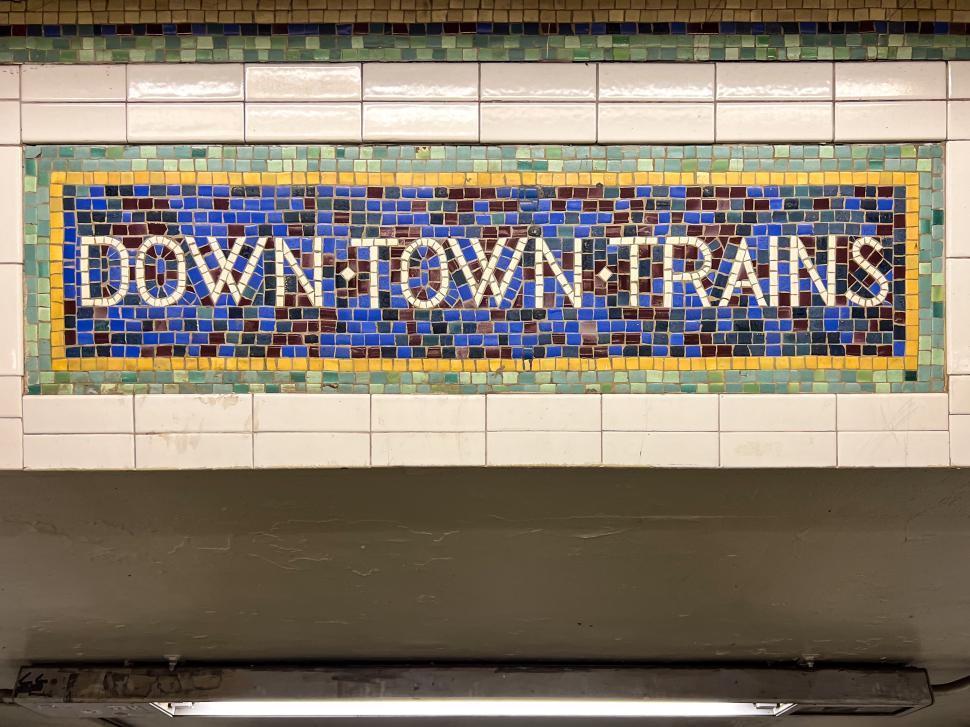 Free Image of Mosaic sign displaying downtown trains at a NYC subway station 