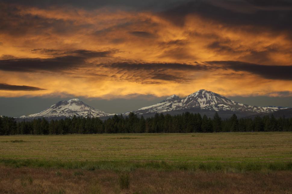 Free Image of Mountains illuminated by sunset with colorful clouds in the sky 