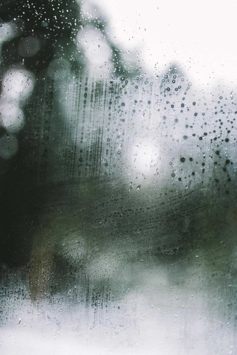 Free Image of Raindrops trickle down a foggy window on a rainy day in the countryside 