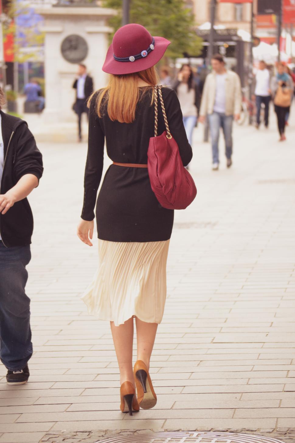 Free Image of Woman in stylish outfit walks down a busy street 