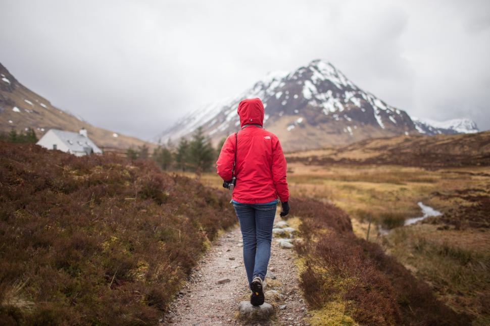 Free Image of Hiker walking along a trail through a Scottish highland landscape in spring 