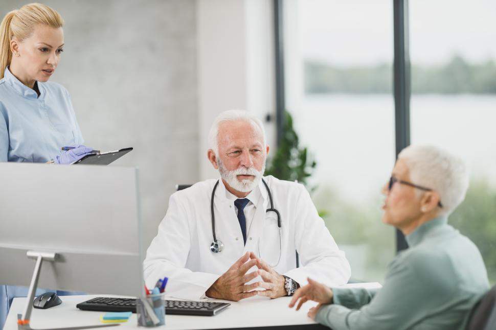 Free Image of Doctor and nurse consult with elderly patient in medical office 