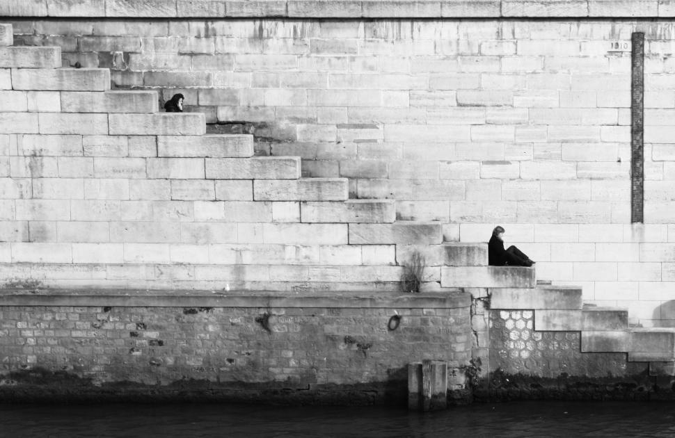 Free Image of People sitting on steps by the river during quiet afternoon 