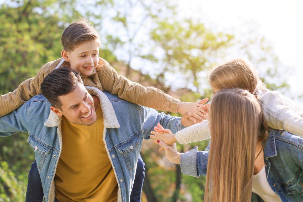 Free Image of Family enjoys playful moments in sunny park setting 