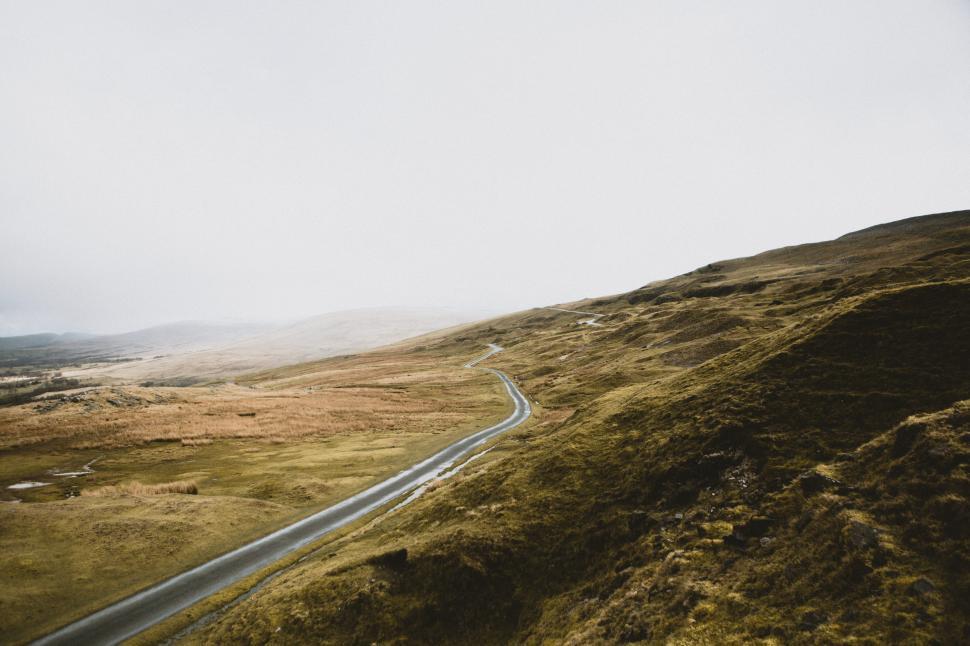 Free Image of Winding road through misty hills in tranquil landscape 