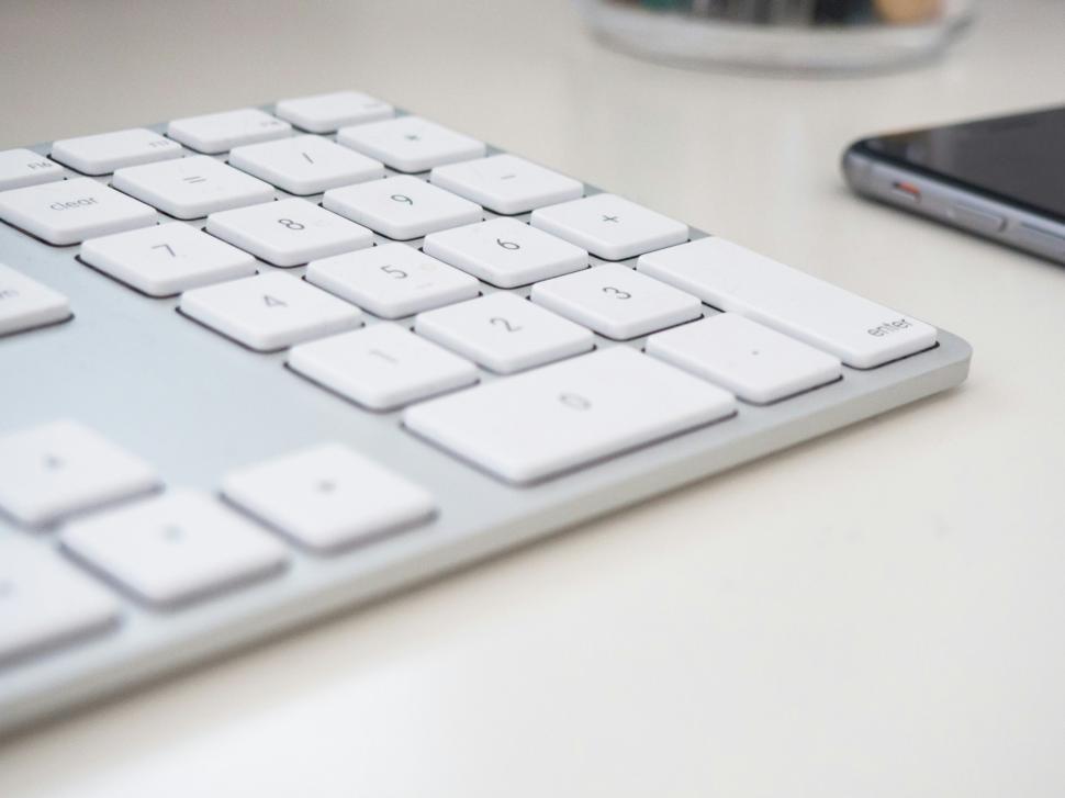 Free Image of Close-up view of a computer keyboard and smartphone on a desk 