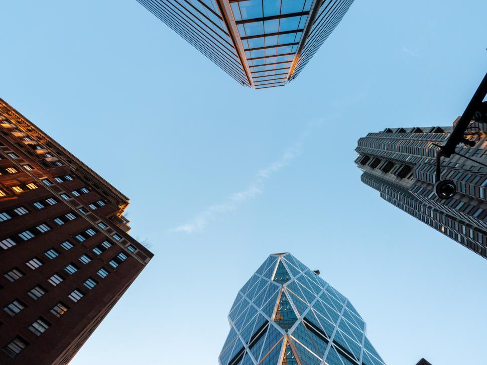 Free Image of Urban skyscrapers tower against a clear blue sky in a vibrant city scene 