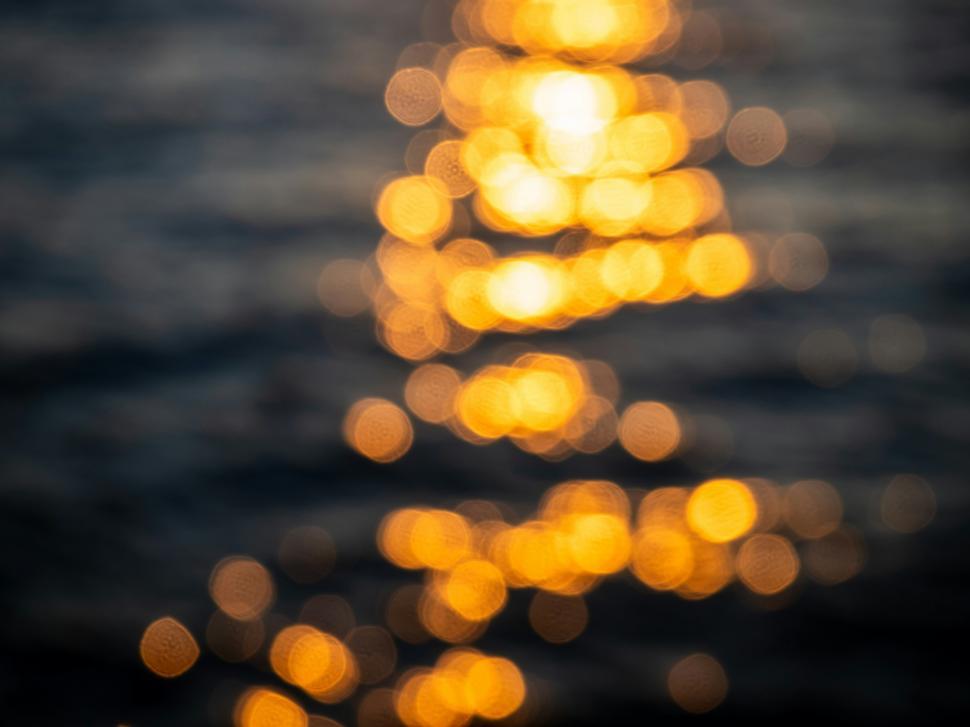 Free Image of Sunset reflections create a shimmering pattern on the water s surface 