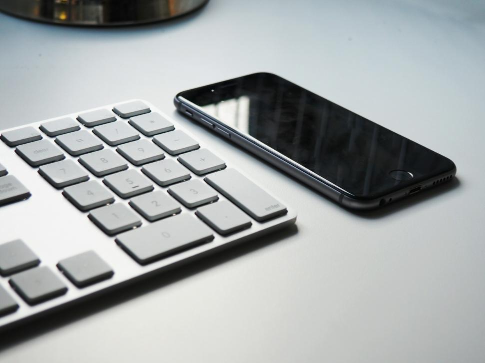 Free Image of Modern workspace featuring a keyboard and smartphone on a clean surface 