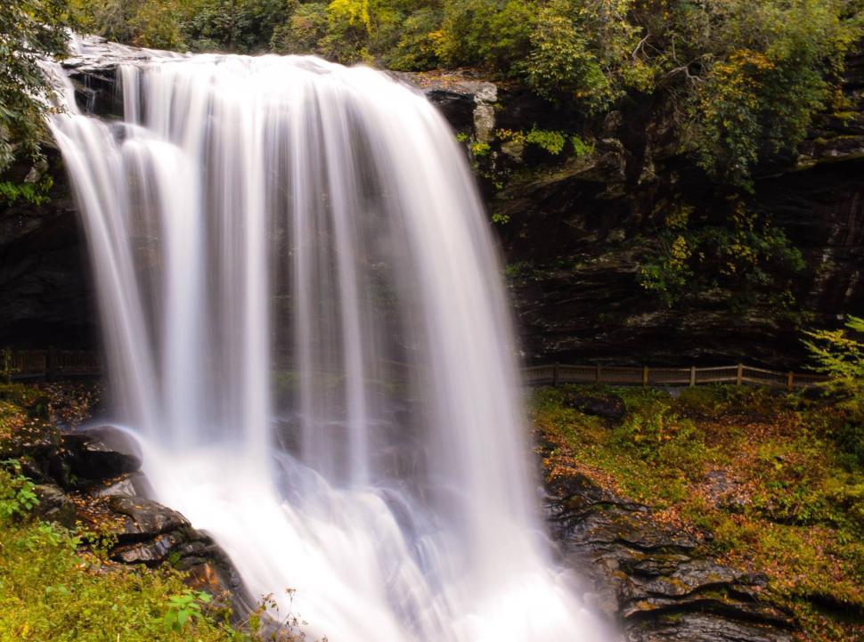Free Image of Majestic waterfall cascades in serene forest setting during autumn 