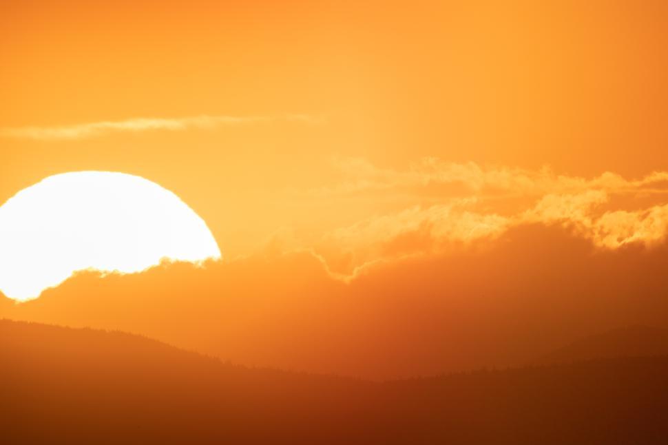 Free Image of Sunset over mountains creates stunning orange sky 