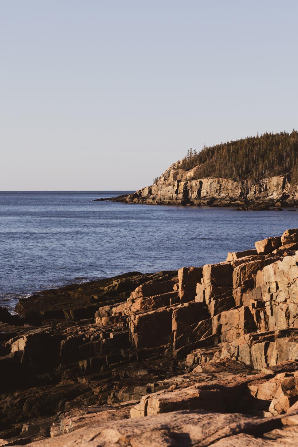 Free Image of Rocky coastline and calm waters at sunset in Maine 