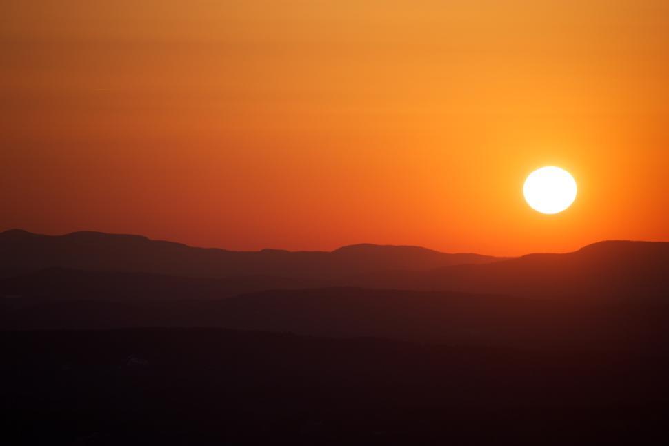 Free Image of Breathtaking sunset over rolling hills in serene landscape 