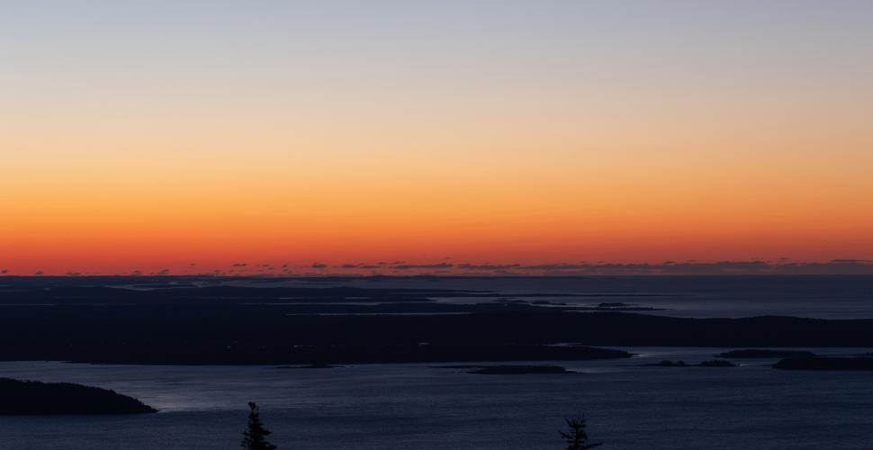 Free Image of Colors of sunset over calm ocean near distant islands 