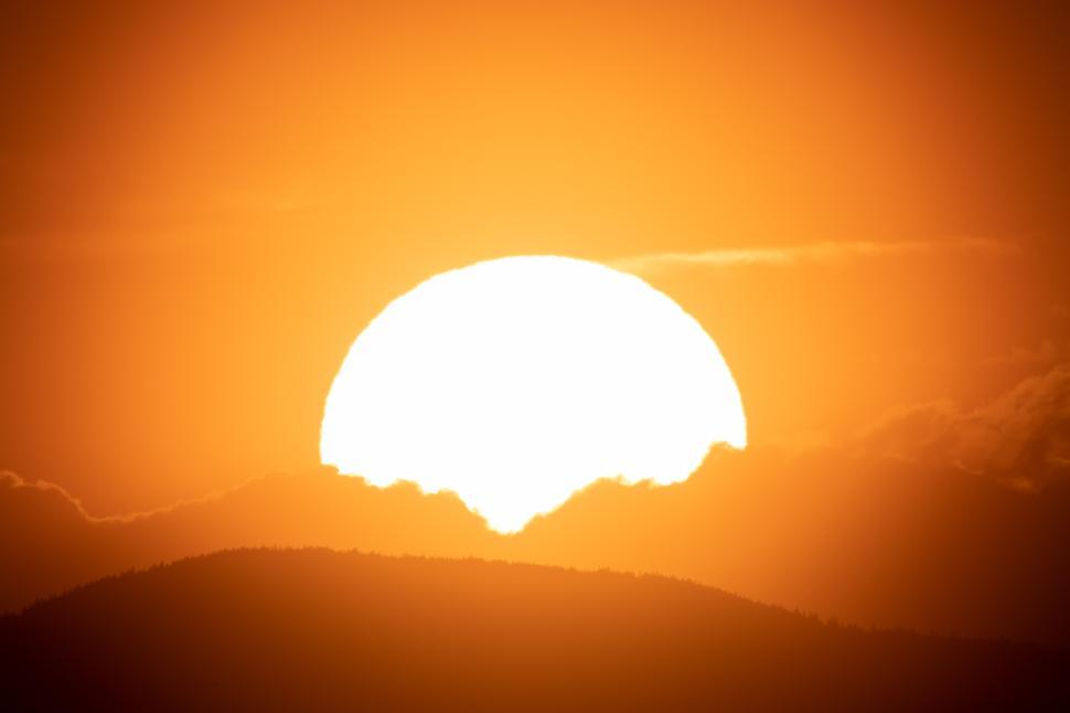Free Image of Magnificent sunset over mountains with glowing orange sky and silhouettes 