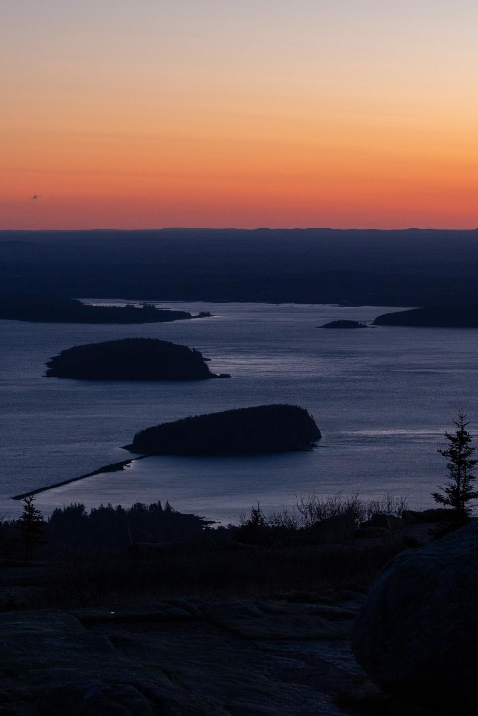 Free Image of Beautiful sunset over a calm lake and islands 