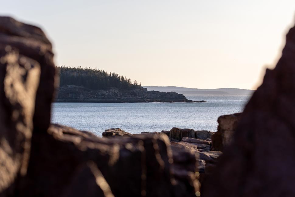 Free Image of Coastal view overlooking calm waters at sunset 