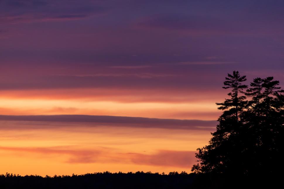 Free Image of Sunset over forest landscape with colorful sky 