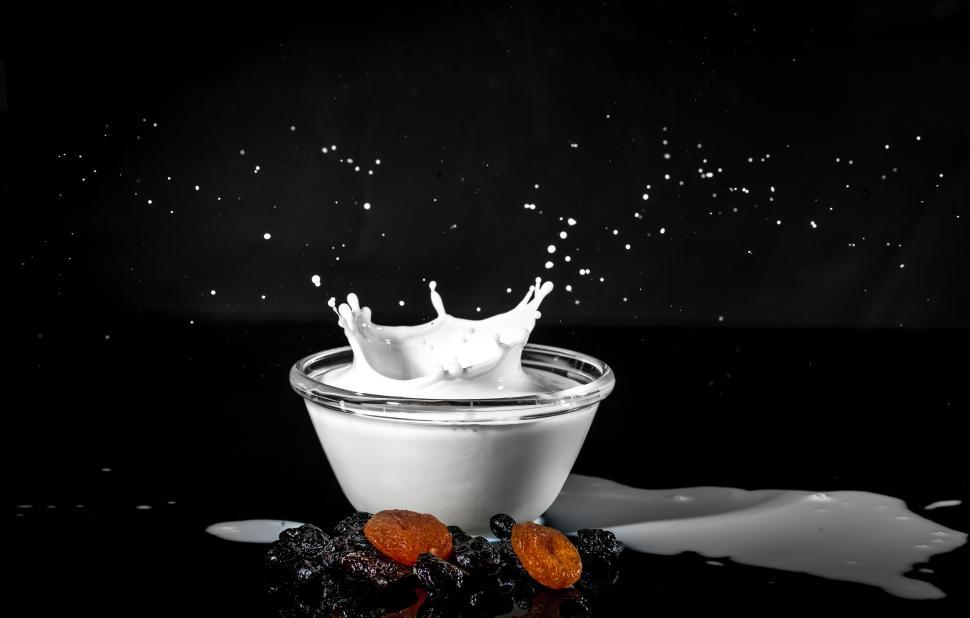Free Image of Creamy milk splash with almonds on a dark background 