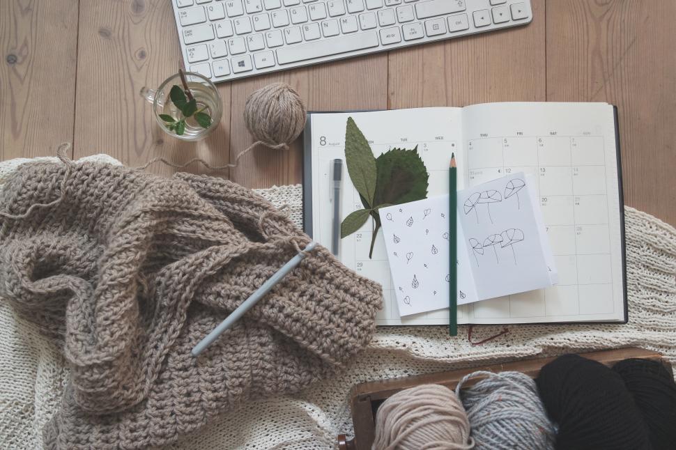 Free Image of Cozy workspace with knitting supplies and calendar on a wooden table 