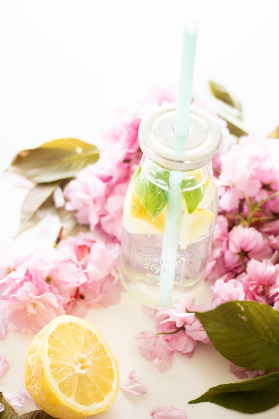 Free Image of Refreshing lemon drink surrounded by pink flowers 