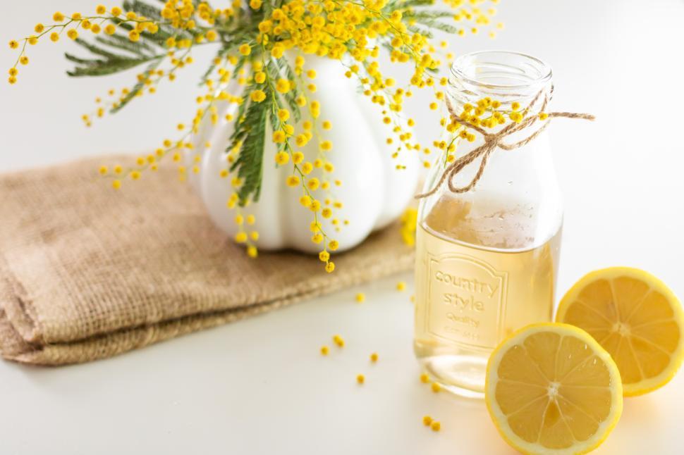 Free Image of Bright lemon beverage with floral arrangement on table 